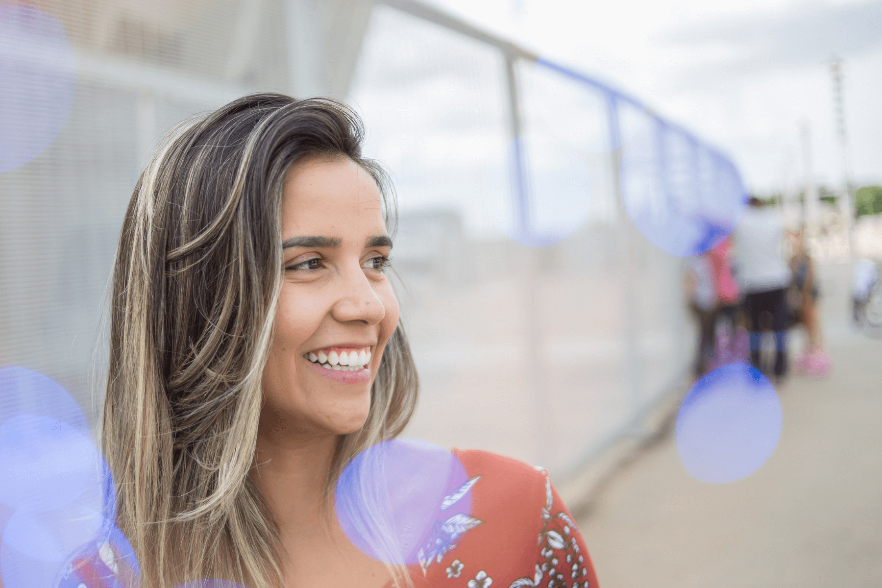 Close up image of young, professional woman smiling and looking into the distance.