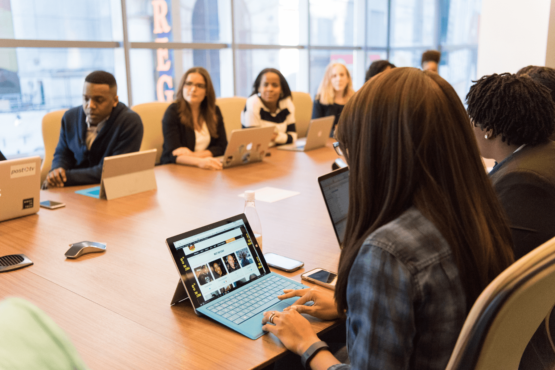 Hard skills vs soft skills: why soft skills are in demand. Group of people in meeting room on laptops.